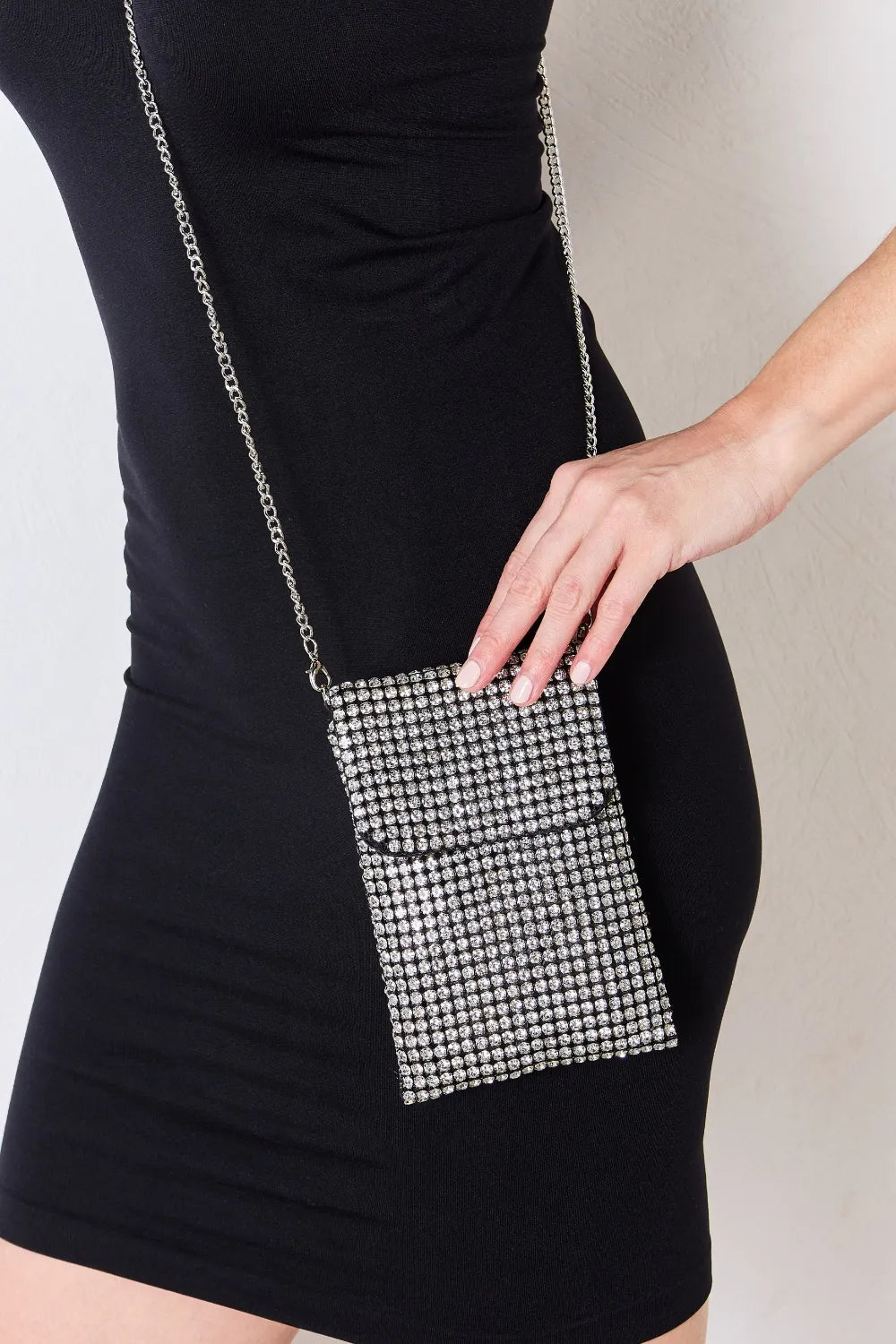 Close-up of Chaos Spark Mini Rhinestone Crossbody Bag styled with black dress, silver chain strap