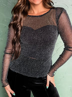 Model wearing the Metallic Glitter Mesh Long Sleeve Top with sheer glitter detail on the chest.